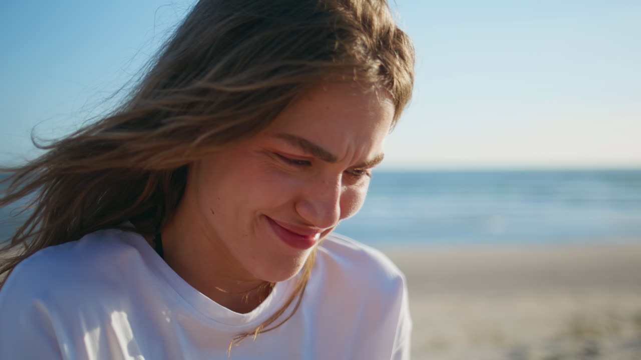 Sunny woman fingers messaging smartphone at sandy beach closeup. Surprised girl