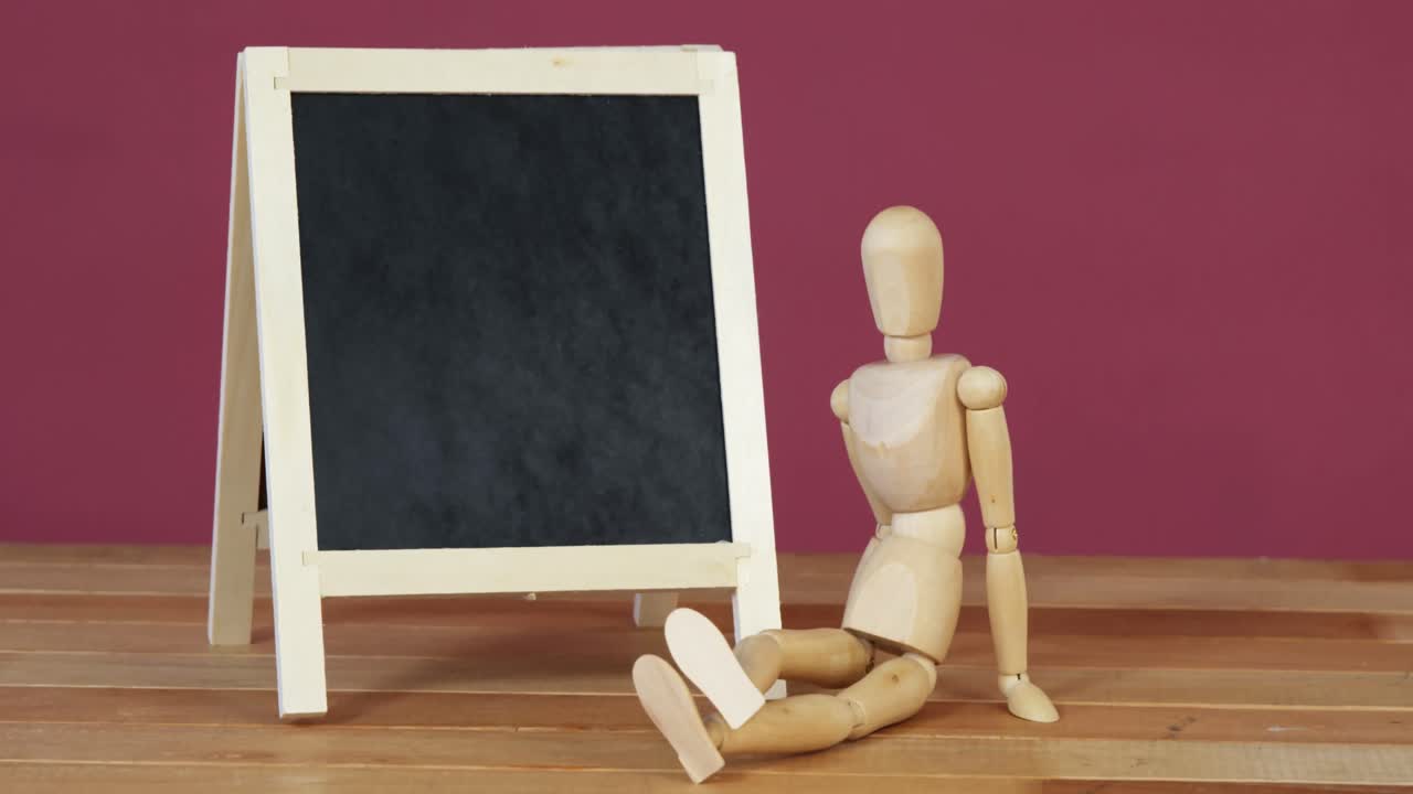 Figurine sitting near a chalkboard