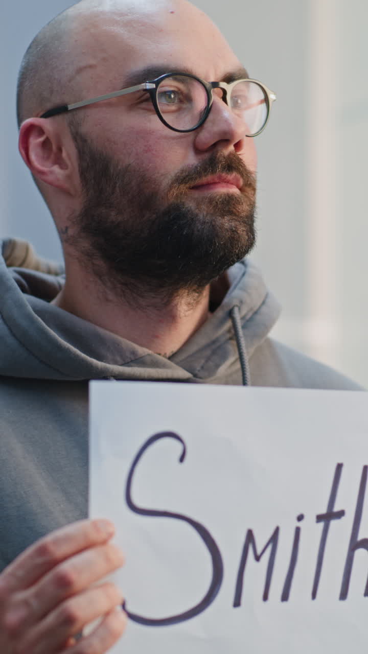 Man holding a sign with the name Smith