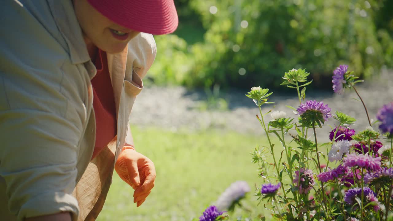 Un giardiniere pota fiori ed erbacce, mostrando le gioie del giardinaggio e della cura delle piante con guanti protettivi e strumenti di potatura in un ambiente esterno soleggiato