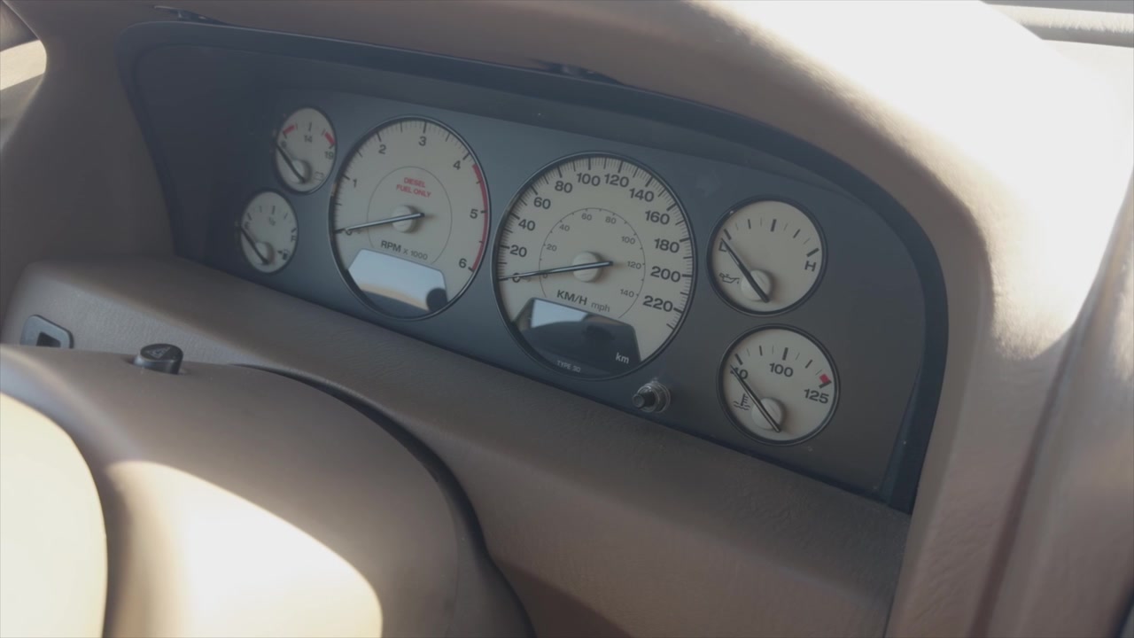 Closeup of car dashboard showing speedometer tachometer and gauges