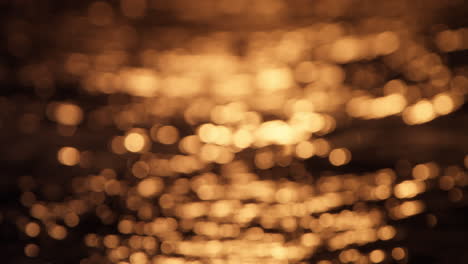 Sun setting over small waves with golden reflections, serene and peaceful scene with warm ocean hues, blurred intentionally for pleasant backdrop