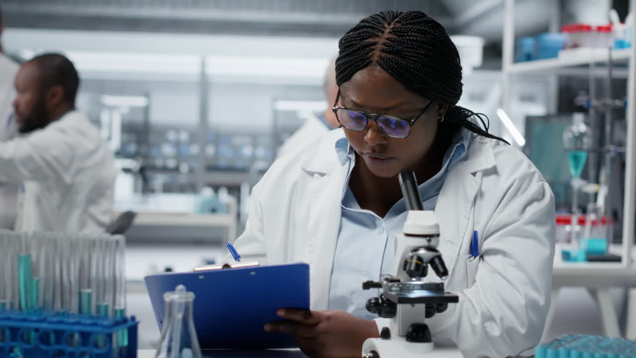 Una scienziata usa un microscopio ottico per studiare microrganismi in laboratorio.