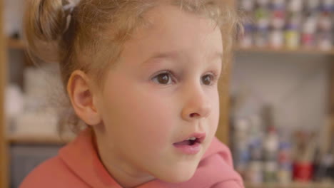 vista de cerca de una niña rubia en un taller de artesanía