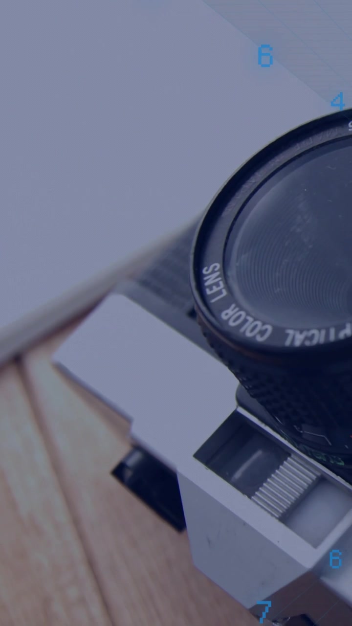 Video verticale: Panoramica della fotocamera, il bordo dell'obiettivo SLR che diventa leggibile, il testo "OPTICAL COLOR LENS" che chiarisce.