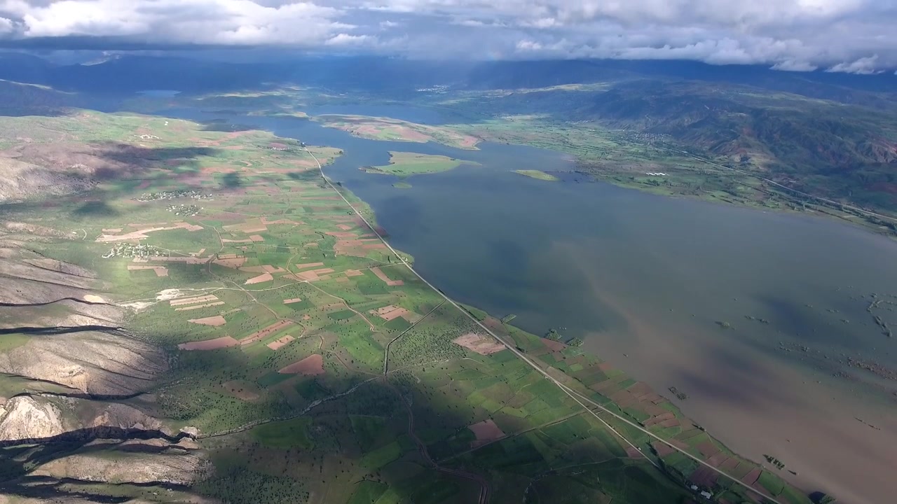 Vista aerea di un vasto lago e campi coltivati.