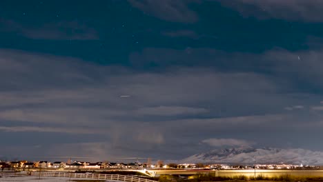 Stars-and-jet-light-trails-cross-the-sky-above-winter-suburban-valley-community---time-lapse