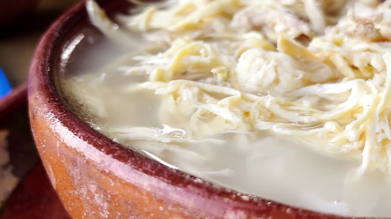 Close-up view of shredded chicken pozole displaying its fibrous texture and creamy color. The chicken is cooked and ready for use in various culinary dishes, highlight its tender and juicy appearance