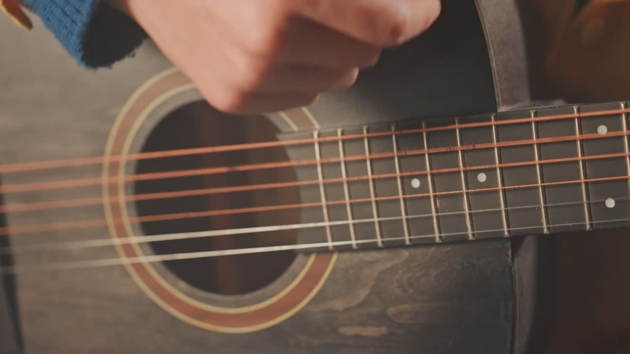 Guitar technique overview. Closeup on string plucking methods. Detailed view of fret hand movements and strum pattern. Intimate shot highlighting chord changes and finger positioning techniques