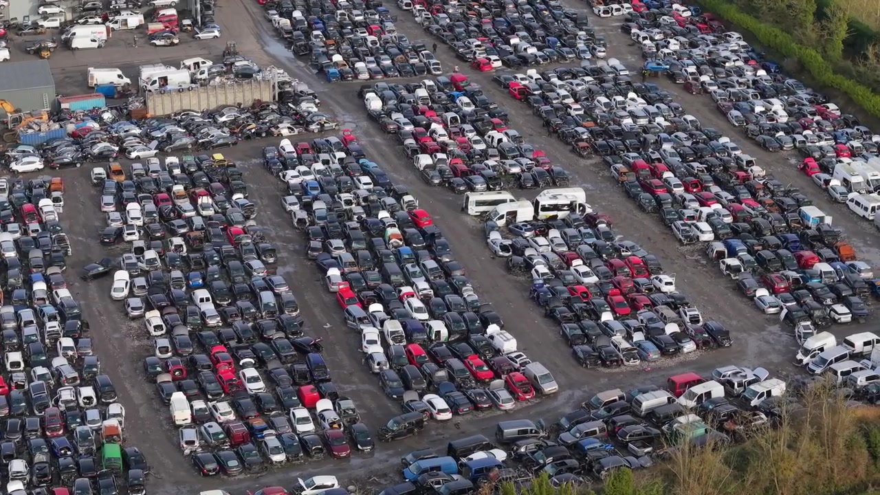 Desguace de coches en Kildare, Irlanda, con filas de vehículos bajo cielos nublados.