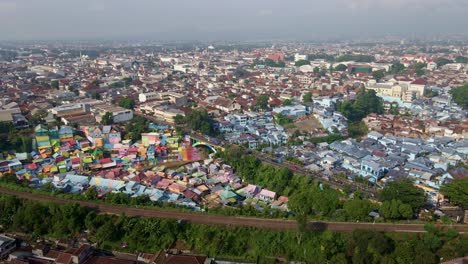 Los-Barrios-Superpoblados-Bordean-La-Orilla-Del-Río,-Yuxtapuestos-A-La-Extensión-Estructural-Del-Puente.