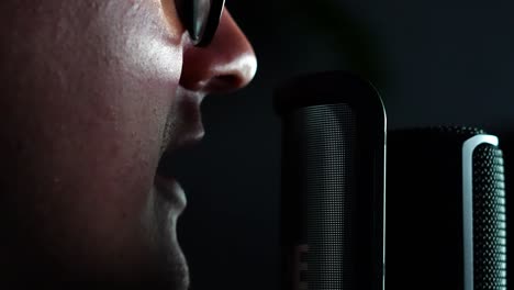 man doing a voice over, capturing sound: voice recording session