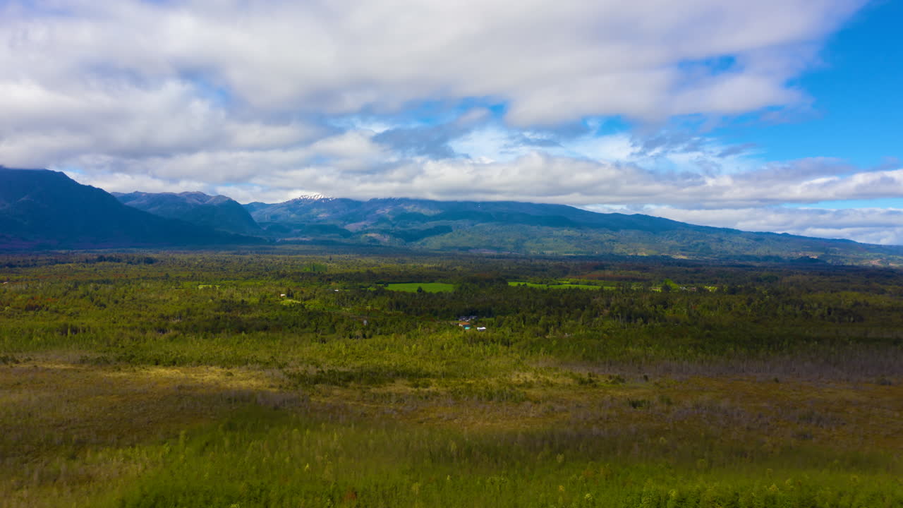 dolly time-lapse mirando a través del campo chileno con montañas en el fondo, día soleado