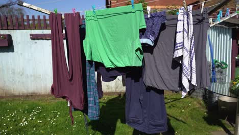 laundry drying on clothes line with wooden fence in the background