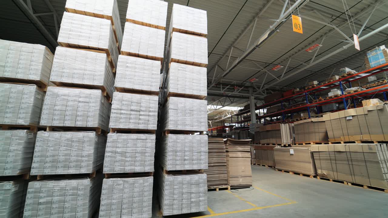 packed pallets of a parquet board stand in the warehouse at a woodworking plant. Warehouse stocks for floorboard sales