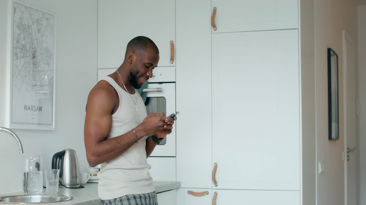 hombre enviando mensajes de texto en la cocina