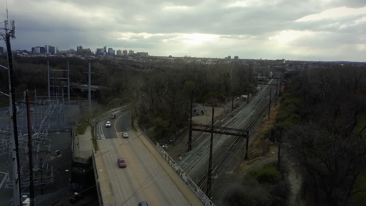 자동차로 가득 찬 고속도로 다리 아래의 철로, 드론 추적 샷