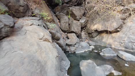 Eine-Dolly-Aufnahme-Eines-Ausgetrockneten-Wasserfalls-Im-Sommer-Und-Eines-Wasserteichs-In-Der-Nähe-Eines-Wasserfallvideos-Im-Hintergrund