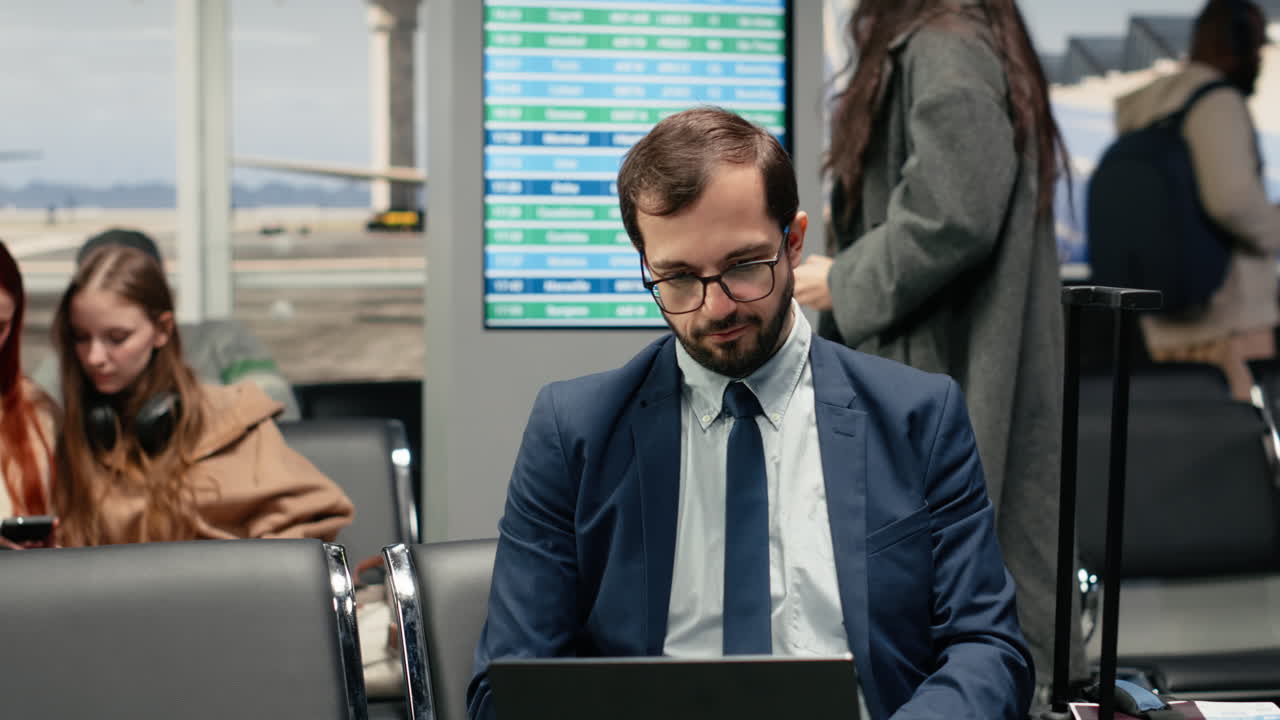 Uomo Freelance in Aeroporto in Attesa dell'Apertura del Gate d'Imbarco, che Lavora al Laptop