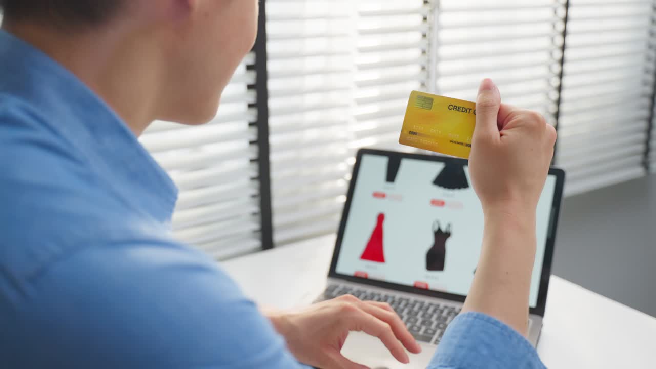 아시안 남성은 쇼핑을 위해 노트북 컴퓨터를 사용합니다. 온라인으로 상품을 판매합니다. 매력적인 잘생긴 남자는 신용카드를 손에 들고 스마트폰에서 웹 사이트에서 상품을 구매하고 구매합니다. 전자 상거래 개념.