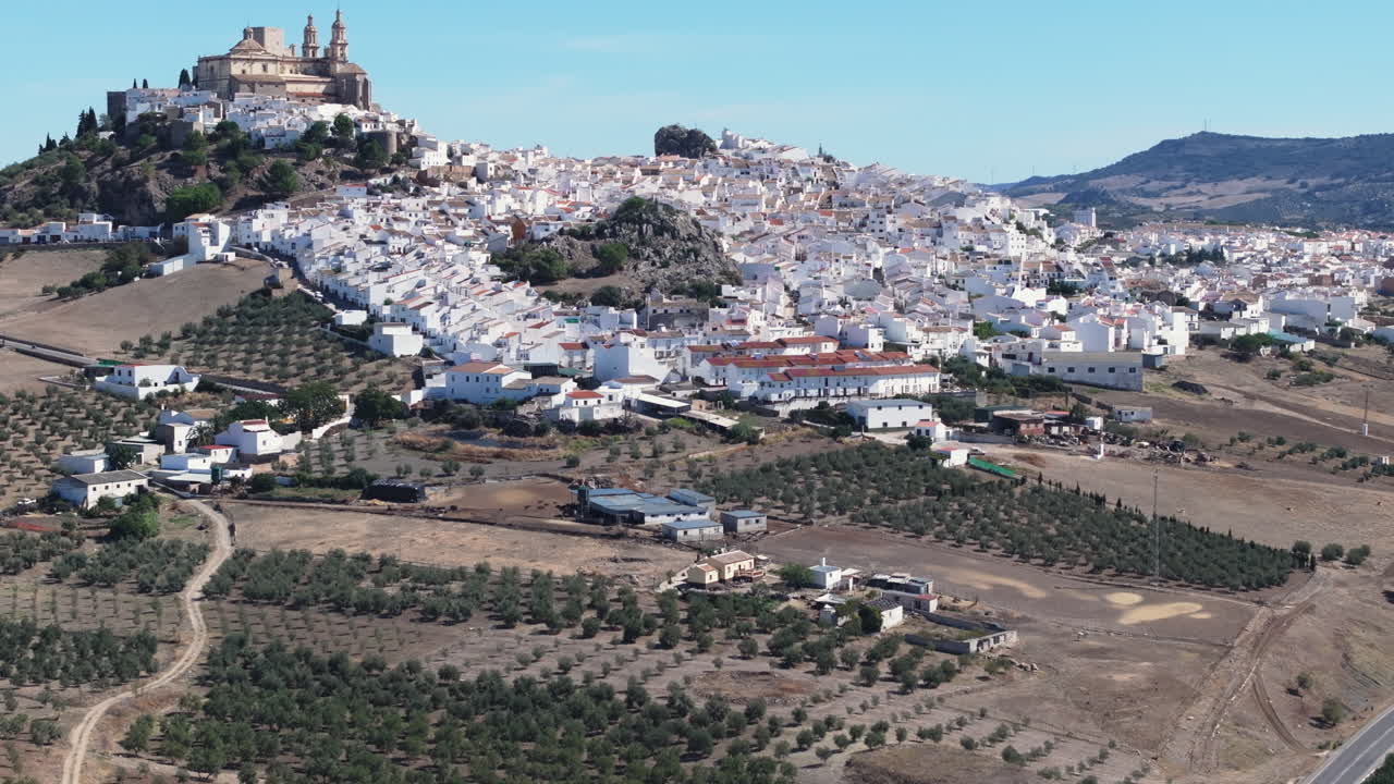 Ripresa aerea con drone, vista panoramica del paese bianco di Olvera in Andalusia, Spagna, Europa. Castello tradizionale e chiesa sulla collina, e alberi di ulivo. Drone in orbita. Color grading cinematografico