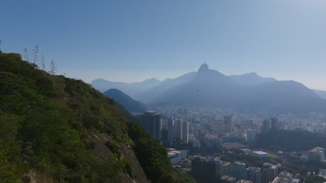 Un-Grupo-De-Pájaros-Volando-En-Círculos-Con-La-Estatua-Del-Cristo-Redentor-Al-Fondo-En-La-Bruma-De-Río-De-Janeiro