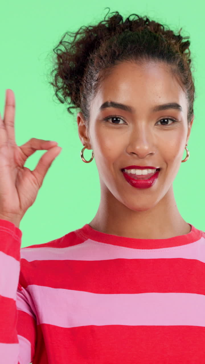 Giovane donna felice che fa il gesto dell'OK su green screen