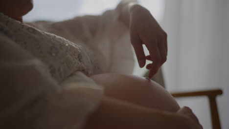 pregnant woman touching belly for upcoming birth