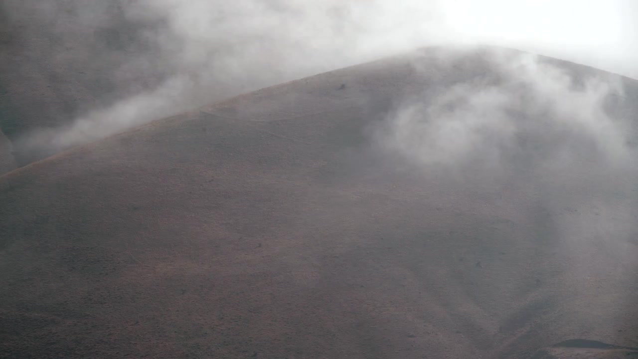Nuvens Densas Movendo-se sobre uma Encosta de Montanha Árida