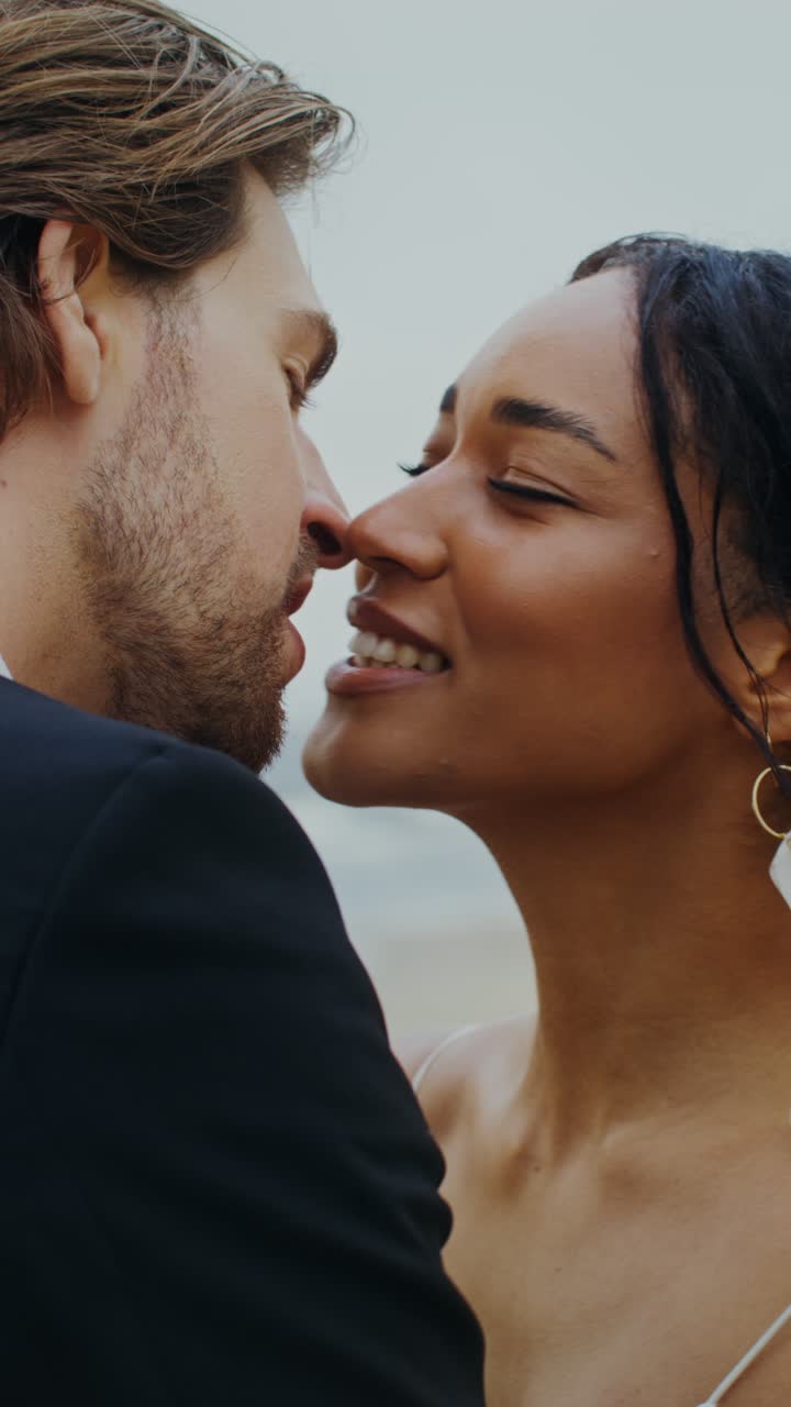 Couple kissing on the beach during their wedding day