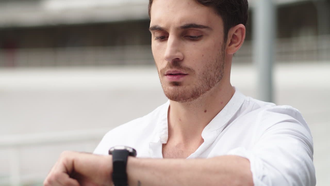 un tipo de primer plano comprobando el tiempo en un reloj inteligente . retrato de un hombre usando un reloj digital