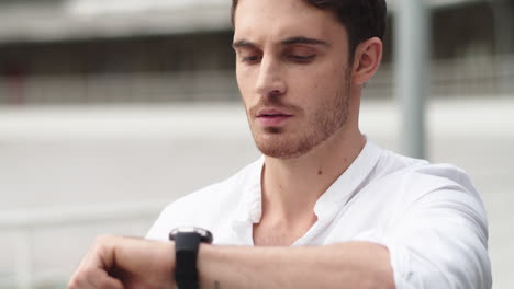 closeup guy checking time on smart watch . portrait man using digital watch