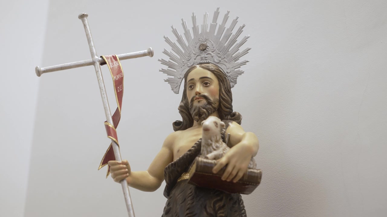 Statua religiosa di Gesù che tiene un agnello e una croce, a simboleggiare sacrificio e salvezza