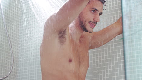 un joven guapo que tiene una ducha refrescante