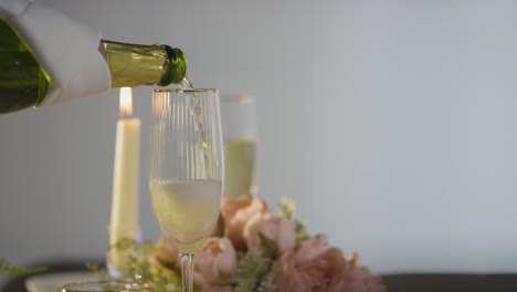 close up of person pouring champagne into glass at table set for meal in restaurant 1