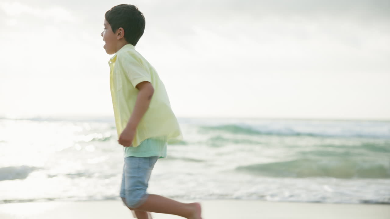 해변에서 달리는 행복한 소년