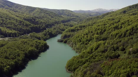 Sobrevuelo-Aéreo,-Inclinación-Lenta-Hacia-Abajo-Sobre-El-Lago-Formado-Por-La-Represa-Maneciu,-Rumania