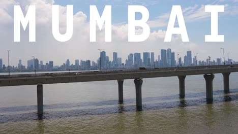 drone shot of mumbai city skyline with bandra worli sea link bridge overlaid with animated graphic spelling out mumbai 1