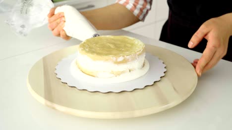 the confectioner covers the cake with cream.