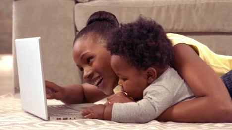 Mother-using-computer-with-her-baby-