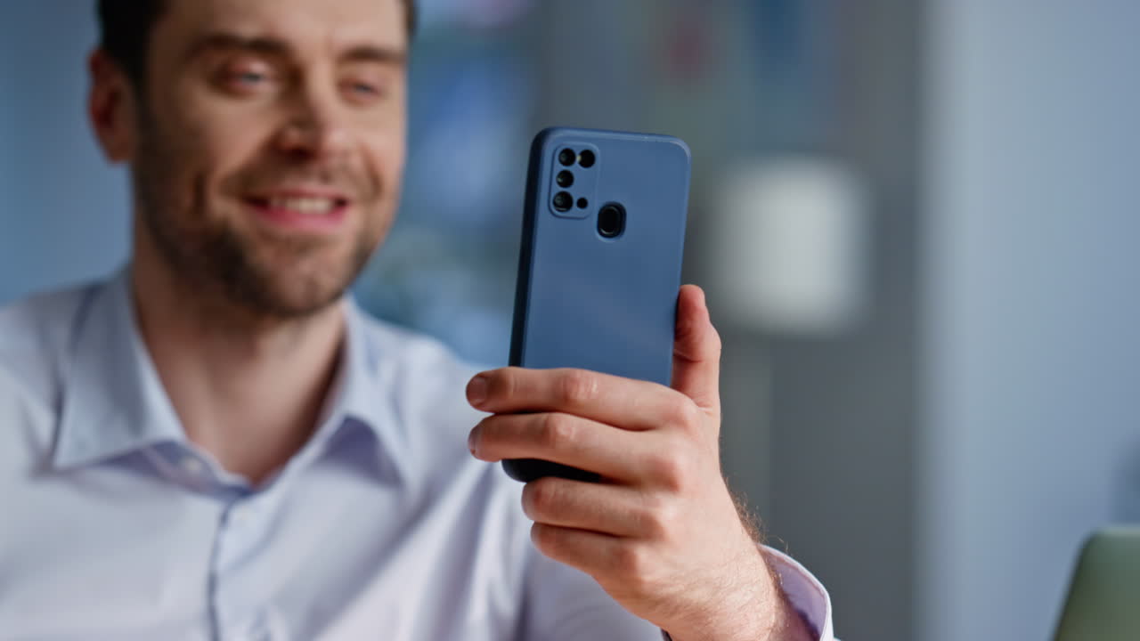 Relaxed freelancer browsing cellphone sitting workplace closeup. Smiling man