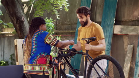 woman aiding man in fixing bicycle