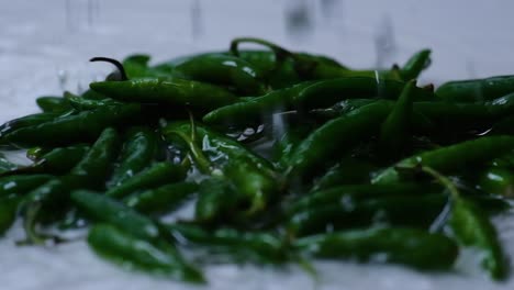 Gotas-De-Agua-En-Cámara-Lenta-Cayendo-Sobre-Chiles-Verdes