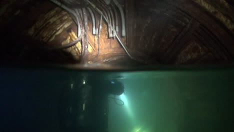 over-under tech diver in flooded silo tunnels