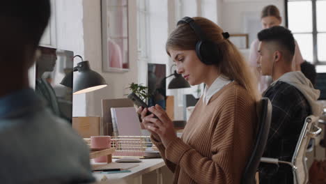 young business woman using computer typing emails working on project in busy office workplace checking messages on smartphone