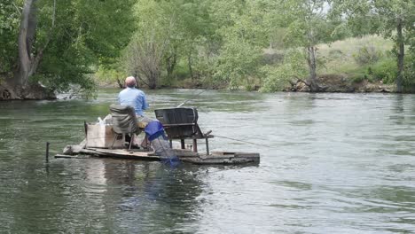 man fishing from a raft on a river