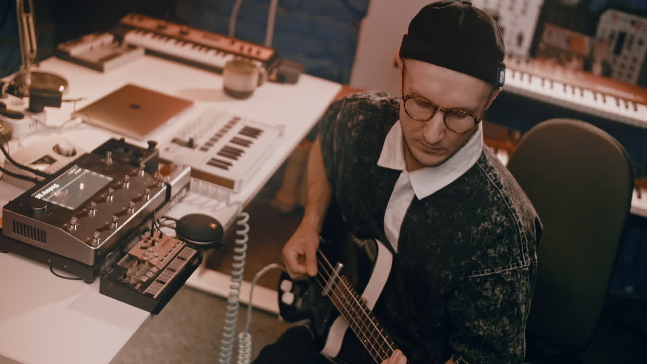 Musician Playing Bass Guitar in a Recording Studio