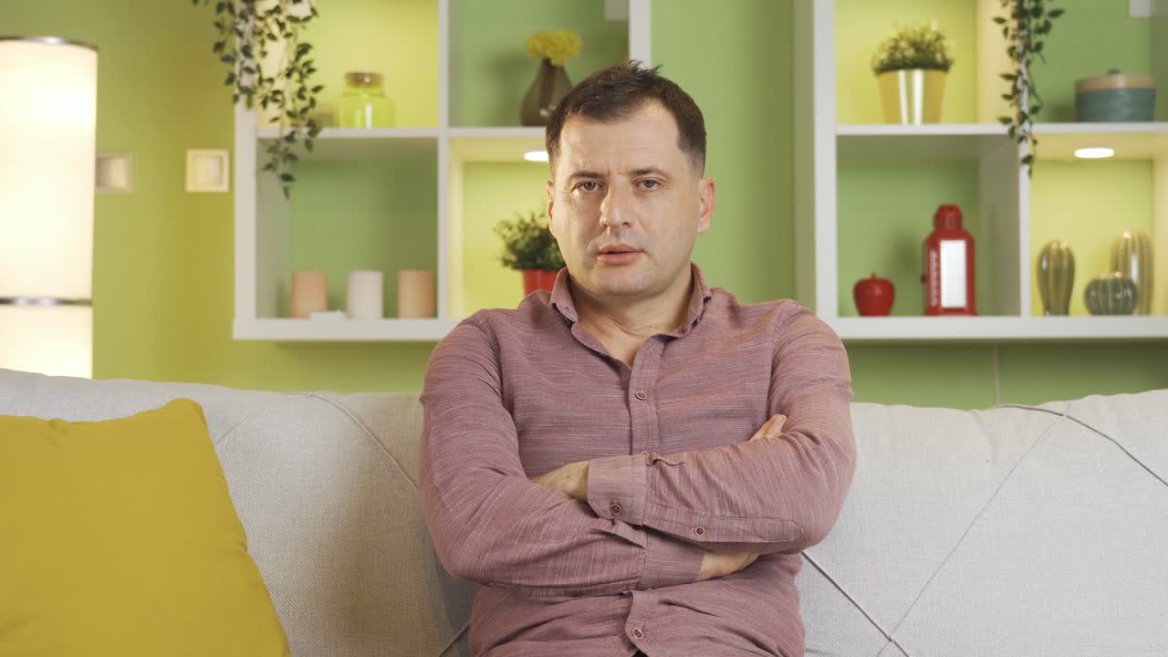 un hombre maduro y triste se aburre en casa.