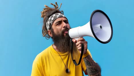young man with dreadlocks and a beard, wearing a vibrant yellow t shirt, passionately shouting into a megaphone during a protest against social issues, set against a striking blue background