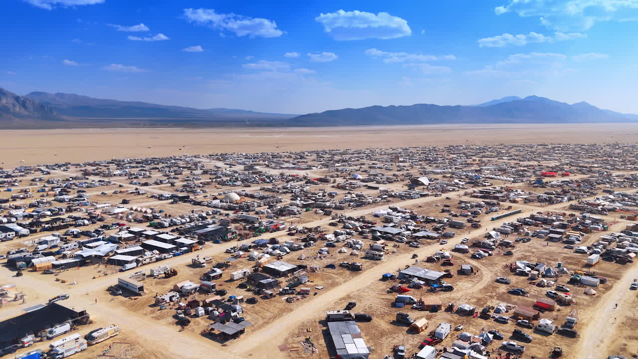 Thousands of cars and campervans in the campsite located in the desert. Encampment of the Burning Man festival in the Black Rock Desert